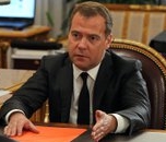 Medvedev, gezeten achter een bureau, legt wat uit