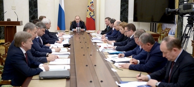 Poetin spreekt sde openingswoorden aan een grote ovale tafel met betrokkenen