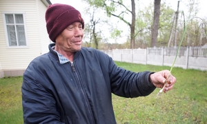 Teremetsky holding a string of garlic in his garden