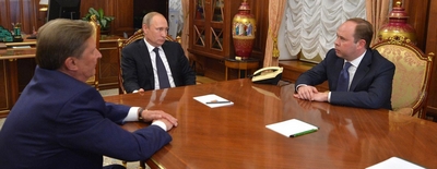 Poetin aan een tafel gefklankerd door Ivanov en Vajno