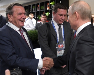 lachende Schroder en Poetin schudden handen