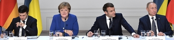 Zelenski, Merkel, Macron en Poetin achter een tafel tijdens de persconferentie